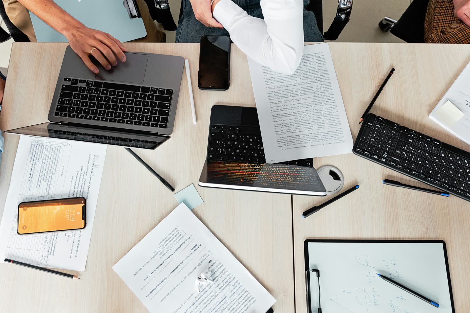 Overhead office desk with laptops, documents, and planning materials
